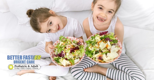 Two young girls holding salads